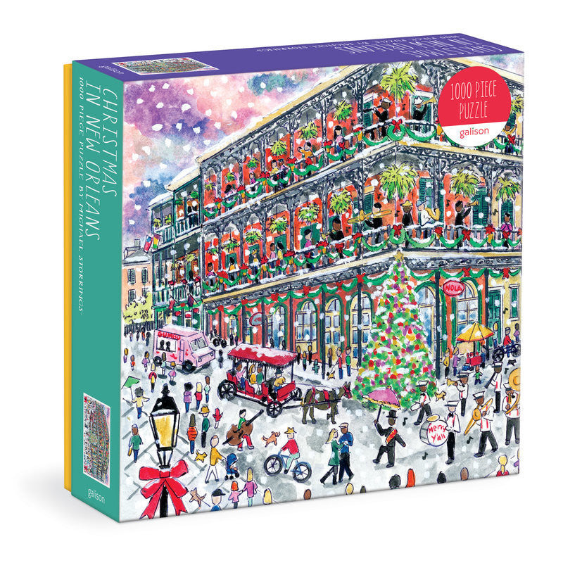 Galison Michael Storrings Christmas in New Orleans 1000-piece jigsaw puzzle featuring festive French Quarter streets decorated with Christmas lights, wreaths, holiday celebrations, and historic architecture.