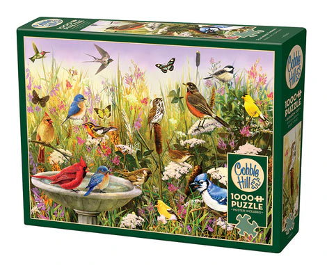 Cobble Hill Feathered Friends 1000-piece jigsaw puzzle featuring a variety of colorful songbirds surrounded by blooming flowers and peaceful garden scenery.