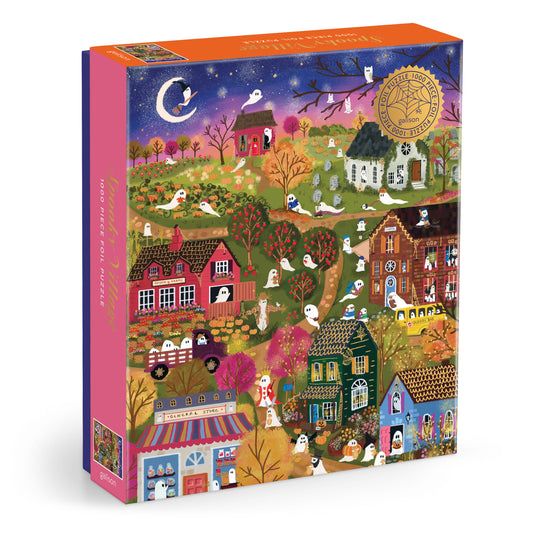 Galison Joy Laforme Spooky Village 1000-piece foil jigsaw puzzle featuring a whimsical Halloween village with haunted houses, pumpkins, ghosts, and foil accents.