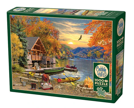 Cobble Hill Lakeside Retreat 1000-piece jigsaw puzzle featuring a peaceful lakeside cabin surrounded by forests, calm water, and beautiful natural scenery.