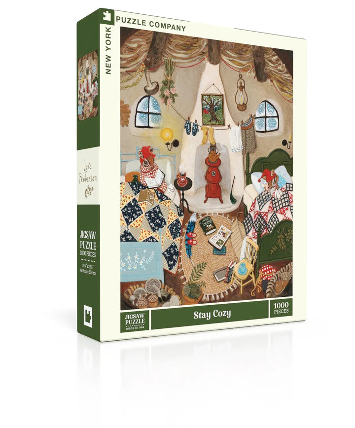 New York Puzzle Company Stay Cozy 1000-piece jigsaw puzzle featuring a cozy home filled with warm blankets, books, and relaxing indoor comforts.