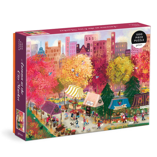 Galison Joy Laforme Autumn at the City Market 1000-piece jigsaw puzzle featuring a lively autumn market filled with pumpkins, seasonal produce, colorful shops, and fall decorations.