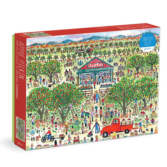 Galison Michael Storrings Apple Pickin' 1000-piece jigsaw puzzle featuring a festive apple orchard with families picking apples, autumn harvest activities, colorful trees, and rustic farm scenery.