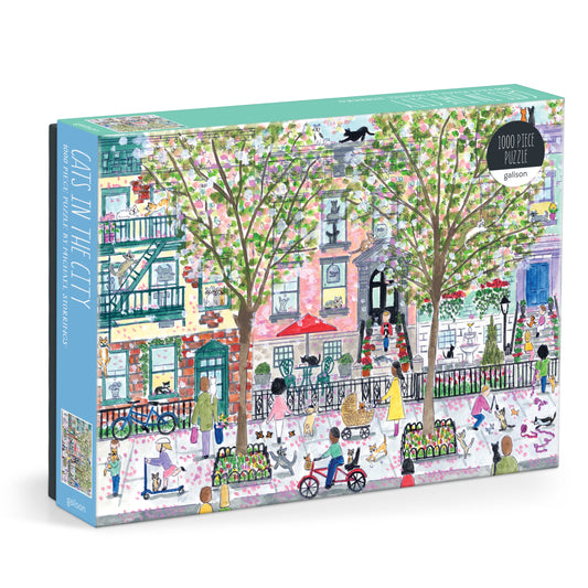 Galison Michael Storrings Cats In The City 1000-piece jigsaw puzzle featuring playful cats exploring colorful city streets, shops, and urban landmarks.
