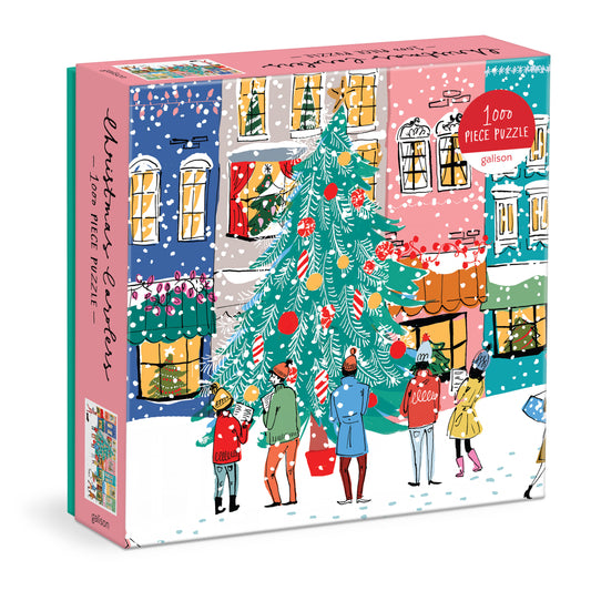 Galison Michael Storrings Christmas Carolers 1000-piece jigsaw puzzle featuring joyful holiday carolers singing beneath festive lights, decorated storefronts, and charming winter streets.