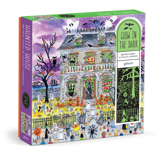 Galison Michael Storrings Haunted House 500-piece glow-in-the-dark jigsaw puzzle featuring a spooky haunted mansion with Halloween-themed artwork.